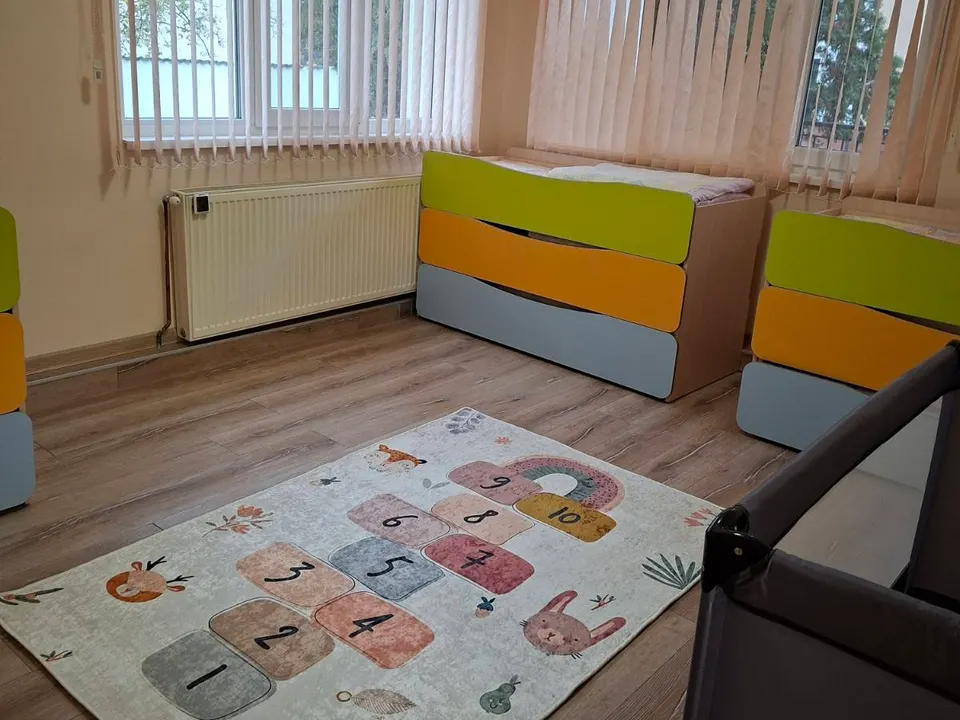 Спалнята: детски легла и мек килим с дама