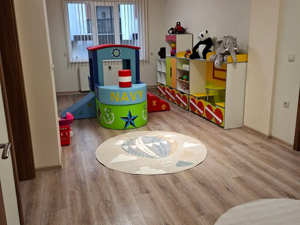 Занималнята в Горубляне: кът за игра, кръгъл килим и рафтове с играчки