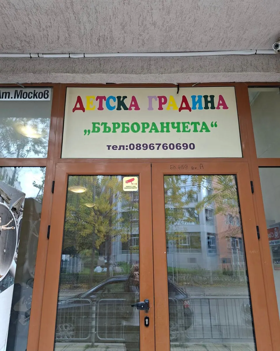 Входът на яслата с табела „Детска градина Бърборанчета“ над вратата